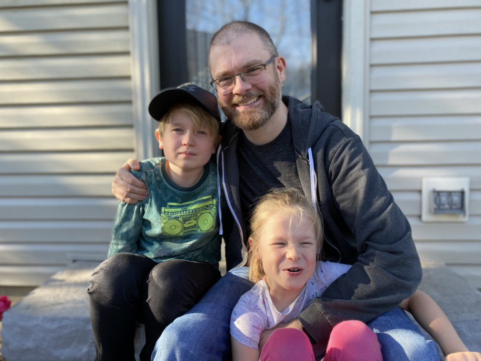 A portrait photograph of Phil Carter with his two children