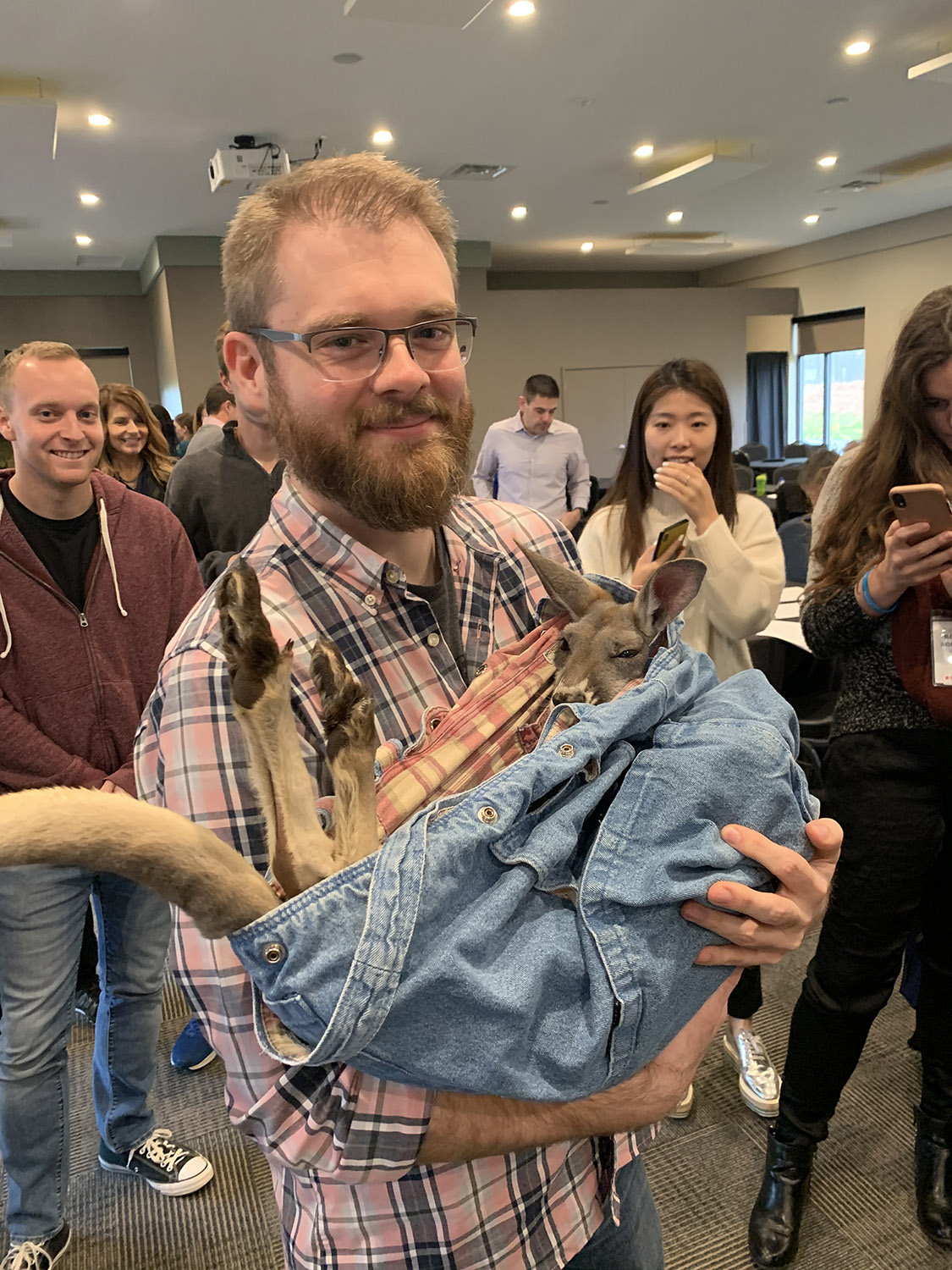 Photograph of Phil Carter holding a baby kangaroo.